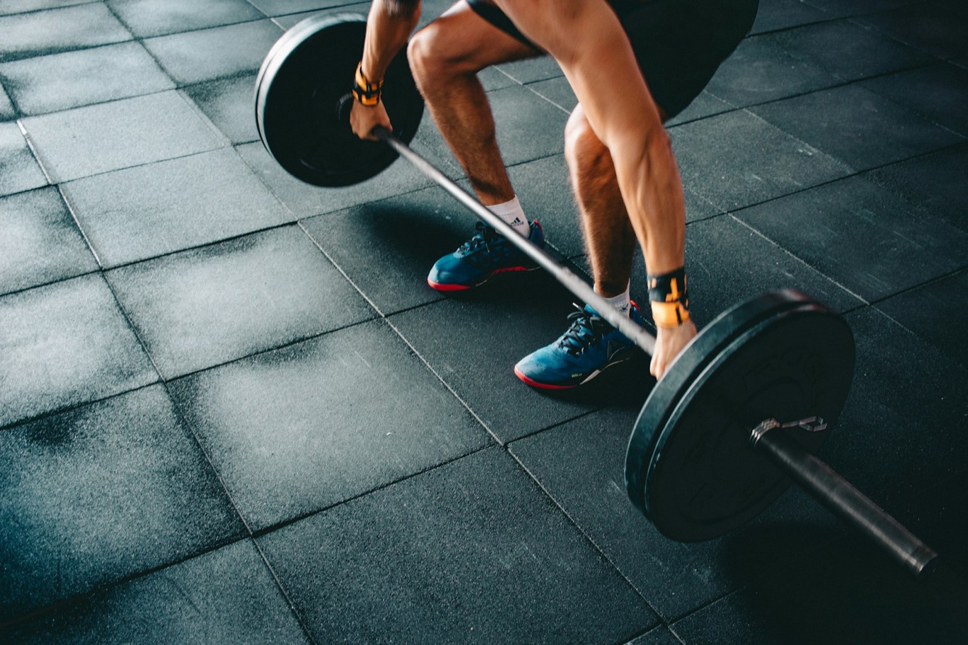 Lifter gripping a loaded barbell for a deadlift